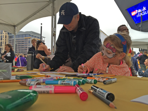 Kelly McNutt draws with a young artist.